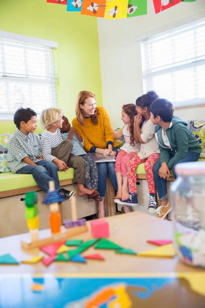 Teacher and students reading in classroom  preschool teacher stock pictures, royalty-free photos & images