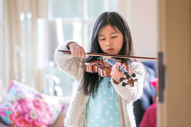 istock Little Girl Playing Violin 505937320