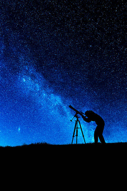 Amateur astronomer Female amateur astronomer looking through a refracting telescope at the night sky. Processed in AdobeRGB colorspace. astronomy telescope photos stock pictures, royalty-free photos & images