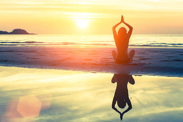 Woman doing meditation on the ocean beach.