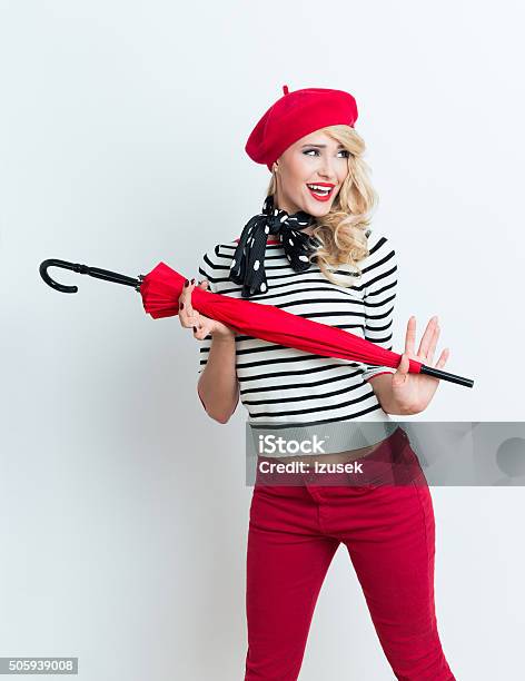 Excited Blonde French Woman Wearing Red Beret Holding An Umbrella Stock Photo - Download Image Now