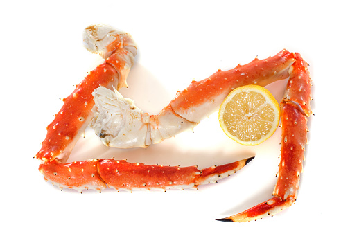 Red king crab leg in front of white background