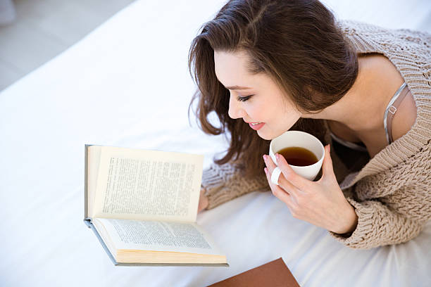 istock Lovely woman reading book and drinking coffee 505939920
