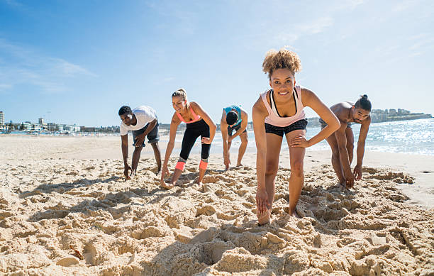 istock Athletic people stretching at the beach 505942278