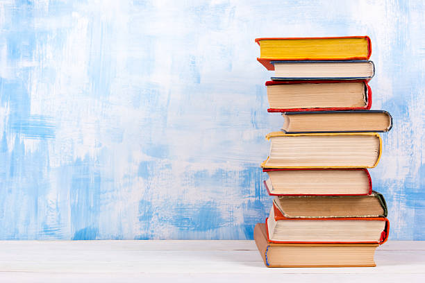 istock Stack of colorful hardback books, open book on blue background 505944018