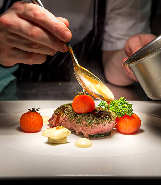 istock Chef plating Tender Lamb with herb crust, cherry tom,Jus 505944108