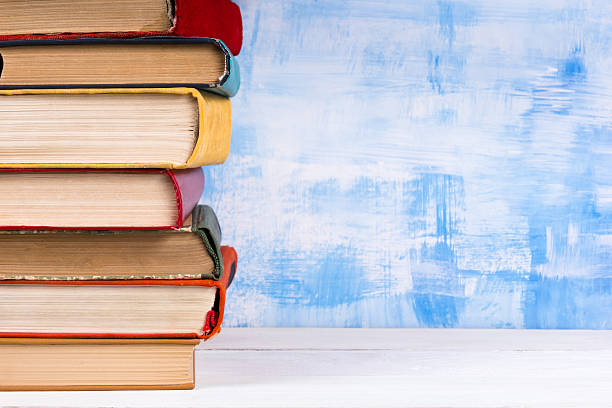 istock Stack of colorful hardback books, open book on blue background 505944168