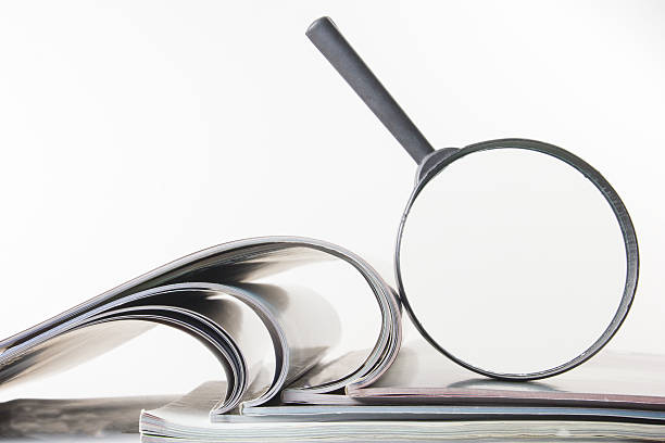 istock Architectural blueprints and blueprint rolls with magnifying glass 505944768