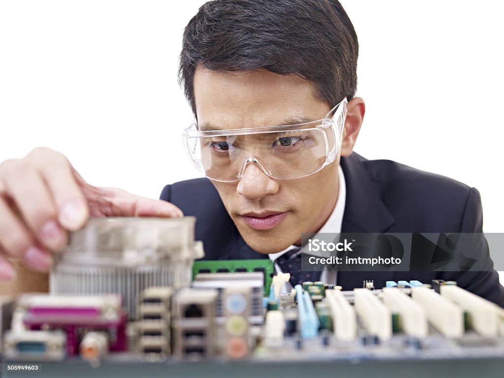 man fixing computer young asian man fixing computer with protective eyewear. IT Support Stock Photo