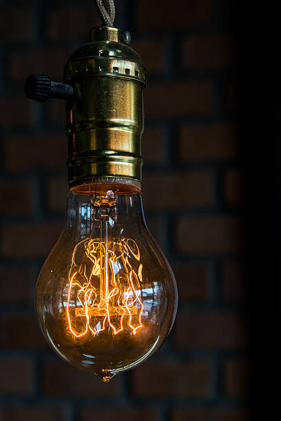 明るいレンガの背景の上の電球 - vertical bright brightly lit vibrant color ストックフォトと画像