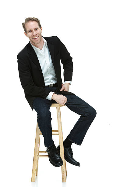 istock Smiling smart casual man sitting on stool 505950839