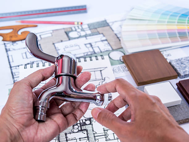 Hand holding faucet, concept of home renovation with architecture drawing stock photo