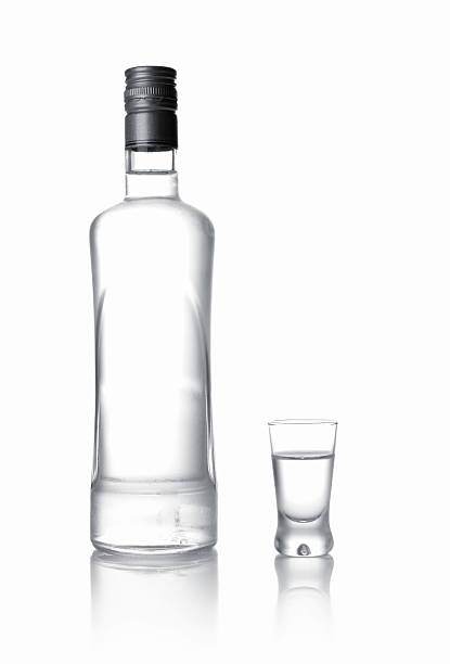 istock Bottle and glass of vodka standing isolated on white 505955011