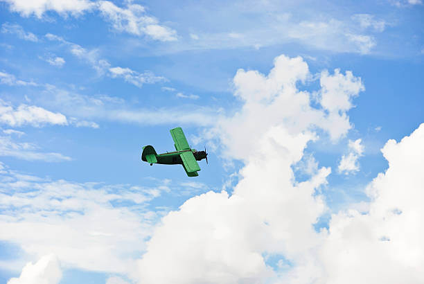istock small green plane flying in blue sky 505956741