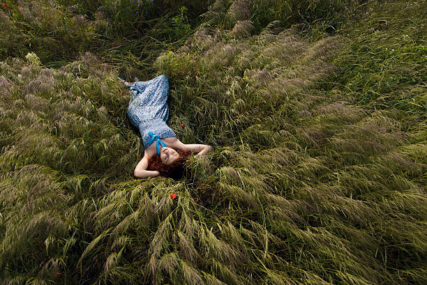 istock Beautiful woman sleeping on tall grass 505956835
