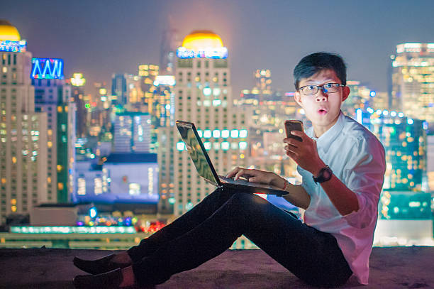 istock Businessman using a laptop on the rooftop of a skyscraper 505966262