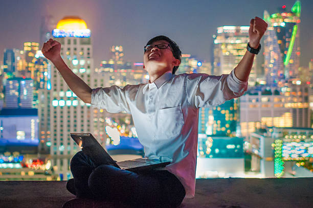 istock Businessman using a laptop on the rooftop of a skyscraper 505966350