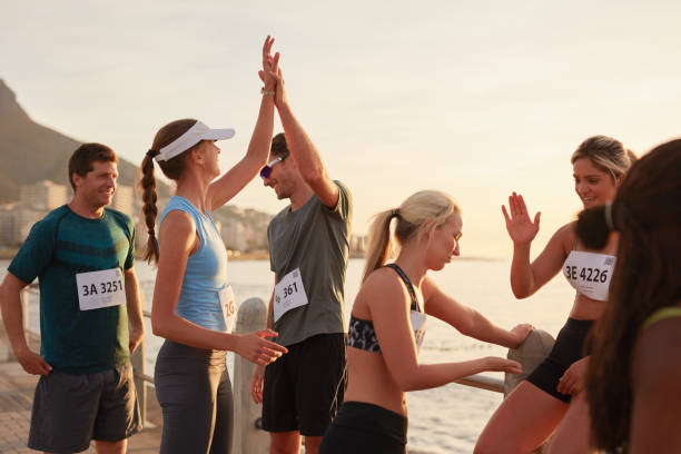 sportler hohe fiving nach einem lauf - athletic event stock-fotos und bilder