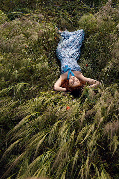 istock Beautiful woman sleeping on tall grass 505976803