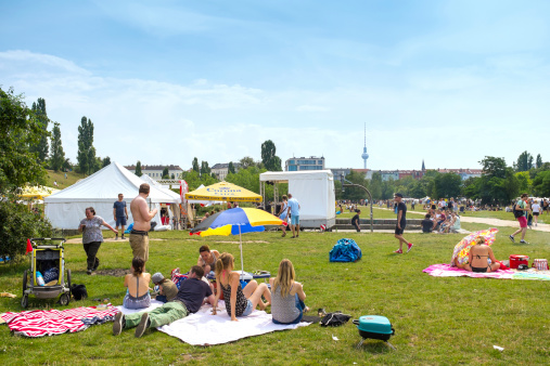 Berlin, Germany - July 27, 2014: Mauerpark packed with people relaxing on the grass or engaged in various leisure activities. Sundays at Mauerpark are famous for their large flee market along with various shows held by all kinds of performers.