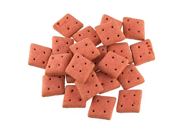 Close up of square  dog biscuits on a white background.