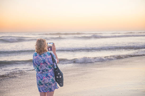 istock Lady photographing the sunset 505988538