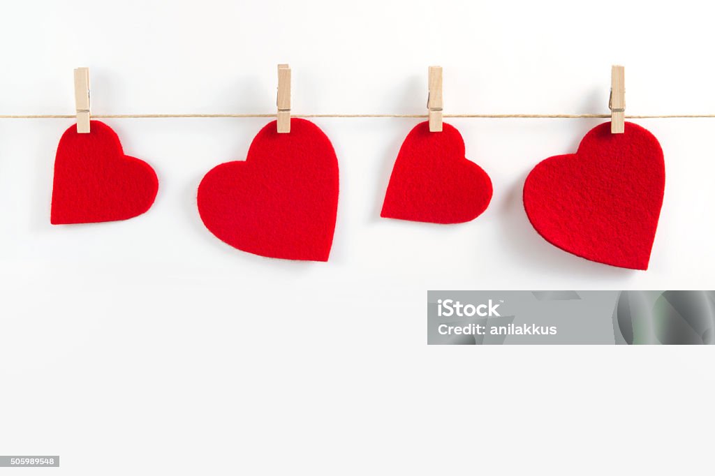 Red  Hearts for Valentine's Day Felt red hearts are hanging with cloth spin on the top of the image.   Banner - Sign Stock Photo