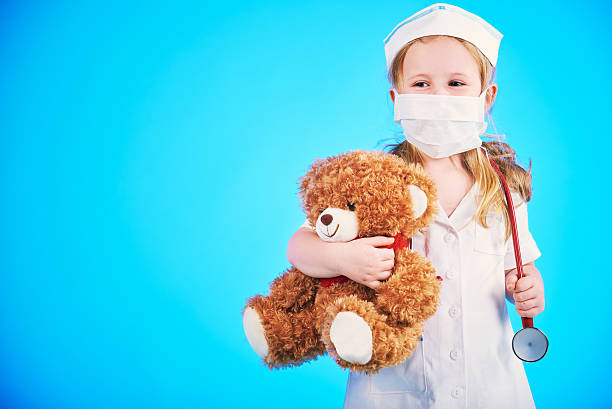 istock Beautiful doctor, nurse examines teddy bear on a blue background 505993456
