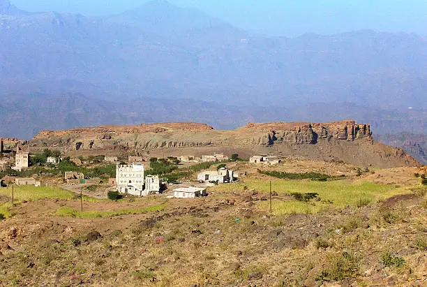 Green terraces and a small settlement along the Sanaa to al-Hudaydah road, Yemen, on a clear day in October; in the background the Jabal Haraz mountains.