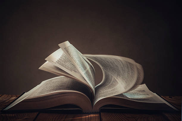 Book Open book with dark background religious text stock pictures, royalty-free photos & images