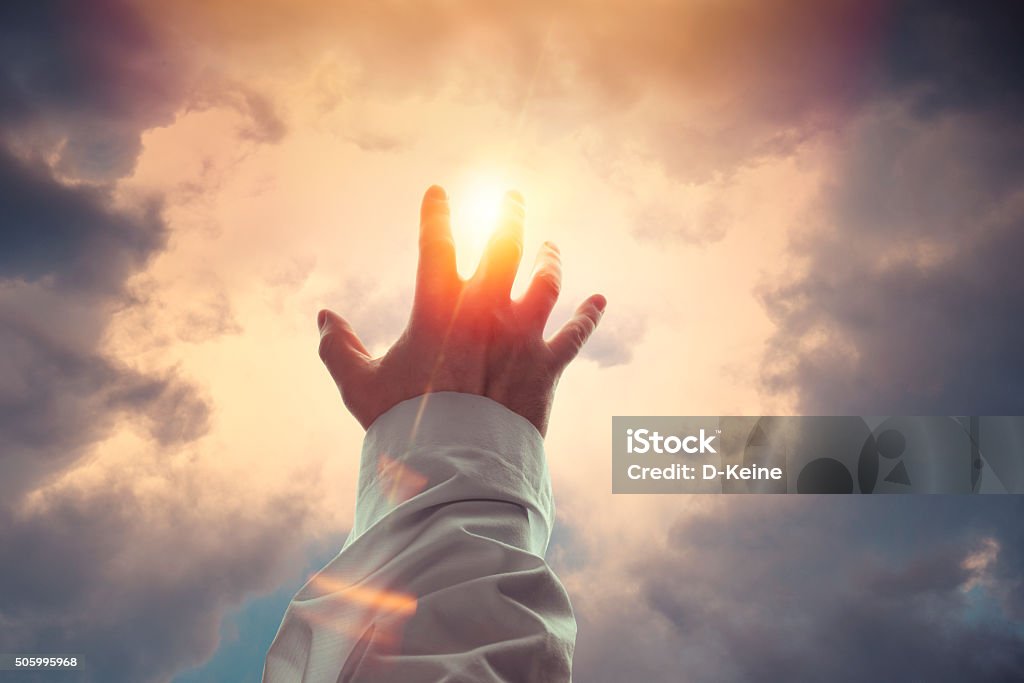 Blessing Male hand reaches a sunshine Jesus Christ Stock Photo