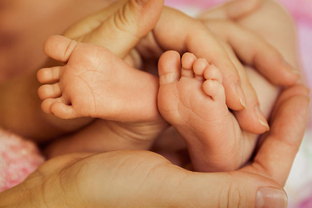istock Baby feet in Mother's hands 506007600