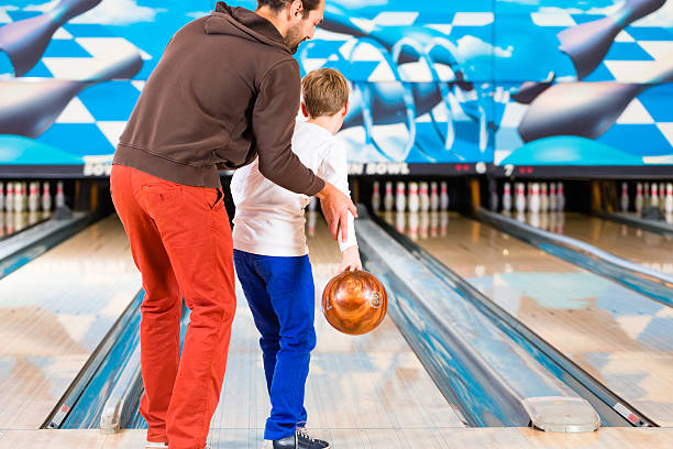 istock Father and son playing in bowling center 506009830