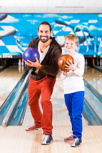 istock Father and son playing in bowling center 506009984