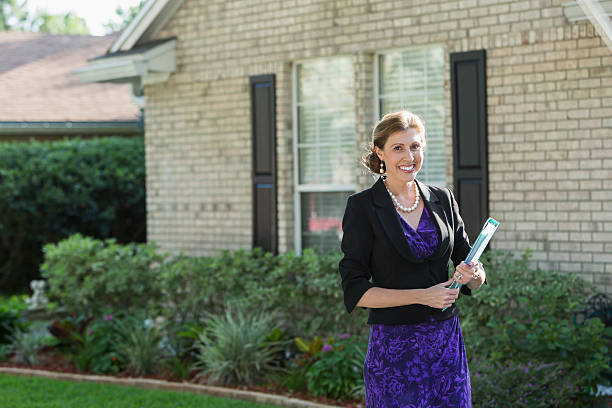 istock Well-dressed woman standing outside home carrying binder 506017118