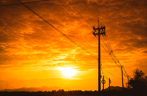 Silhouette electricity post with beautiful sunset background.