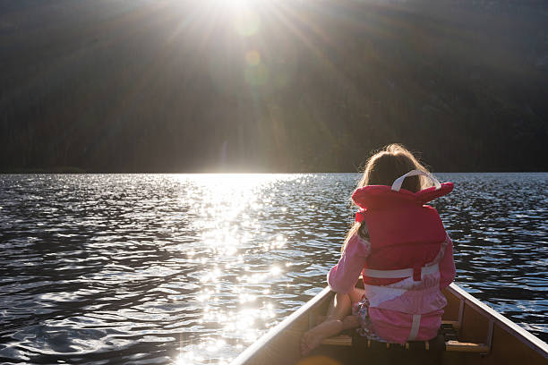 istock Child canoeing on a prisitine mountain lake 506034578