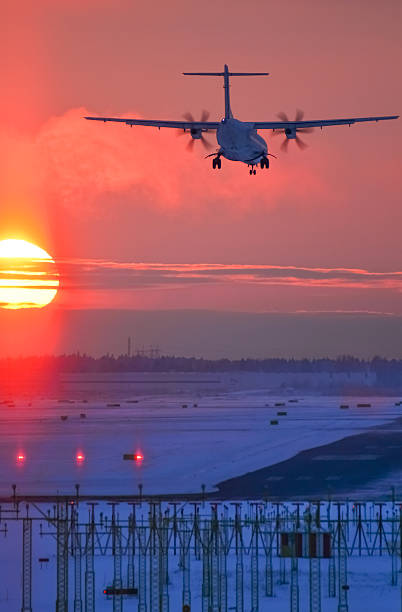 istock Airplane landing at sunset 506036660