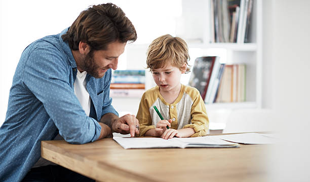 Dad's really good at explaining stuff Shot of a father helping his son with his homeworkhttp://195.154.178.81/DATA/i_collage/pu/shoots/806041.jpg homework stock pictures, royalty-free photos & images