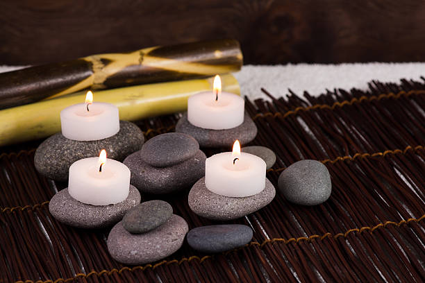 istock Bamboo Spa massage stone and white candles 506040550