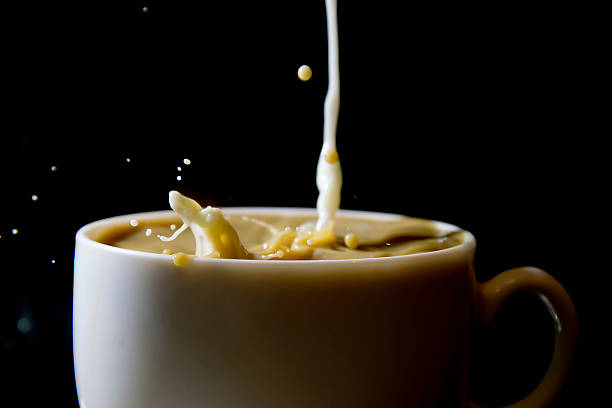 istock Milk splash over cup of black coffee 506041418
