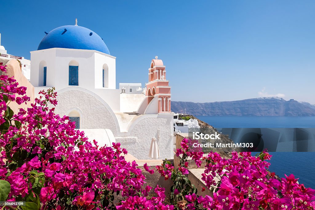 Scenic view of traditional cycladic houses with flowers in foreg Scenic view of traditional cycladic houses with flowers in foreground, Oia village, Santorini, Greece Santorini Stock Photo