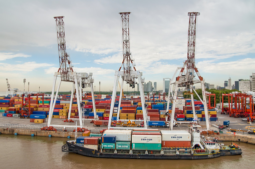 Buenos Aires, Argentina - December 16, 2012: Cargo ships with shipping containers at a container terminal in Puerto Nuovo, Buenos Aires, Argentina on a overcast weather.