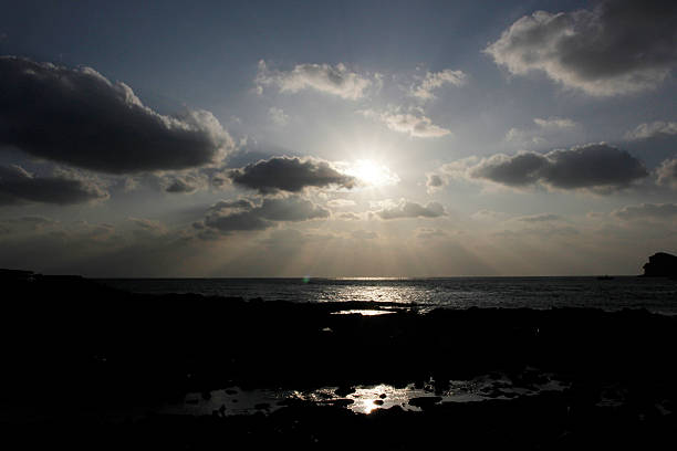 rock spiaggia e sole riflesso sull'oceano - reflection water rock beach foto e immagini stock