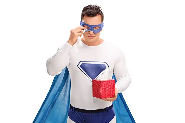 Sad superhero holding a box of wipes and crying isolated on white background