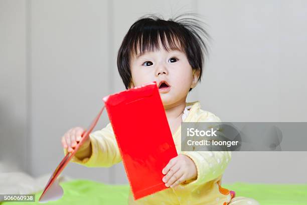 Sweet Esat Asian Little Baby Girl Sitting On Bed Stock Photo - Download Image Now - Baby Girls, Chinese New Year, Red Envelope