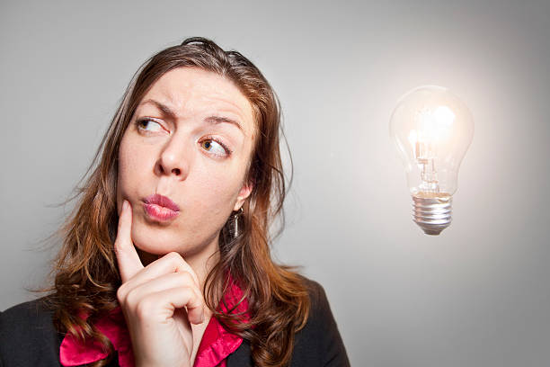 istock A woman in a suit thinks next to a lightbulb. 506061717