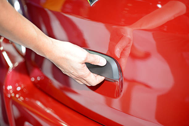 istock Man opens the door to a new red car 506063342