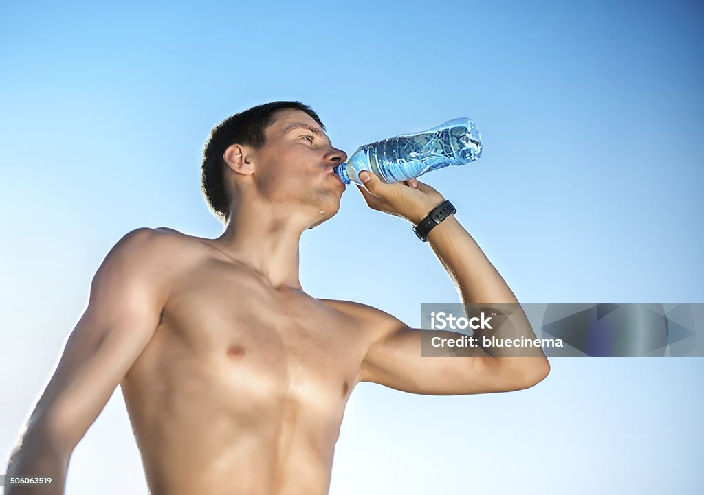 Hombre joven bebiendo agua - Foto de stock de 20 a 29 años libre de derechos