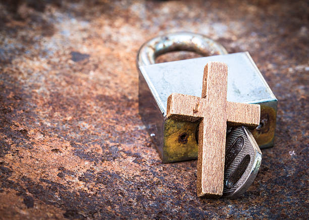 metal lock and key with wooden cross stock photo